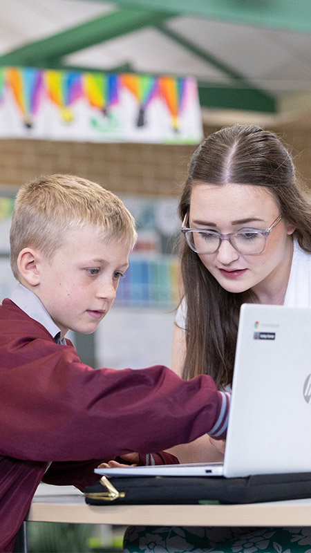 Chisholm Catholic Primary, Bligh Park students in class, the teacher is assisting the students