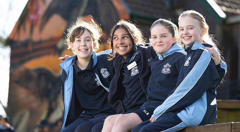Four OLN Lawson students sitting out the front of the school church