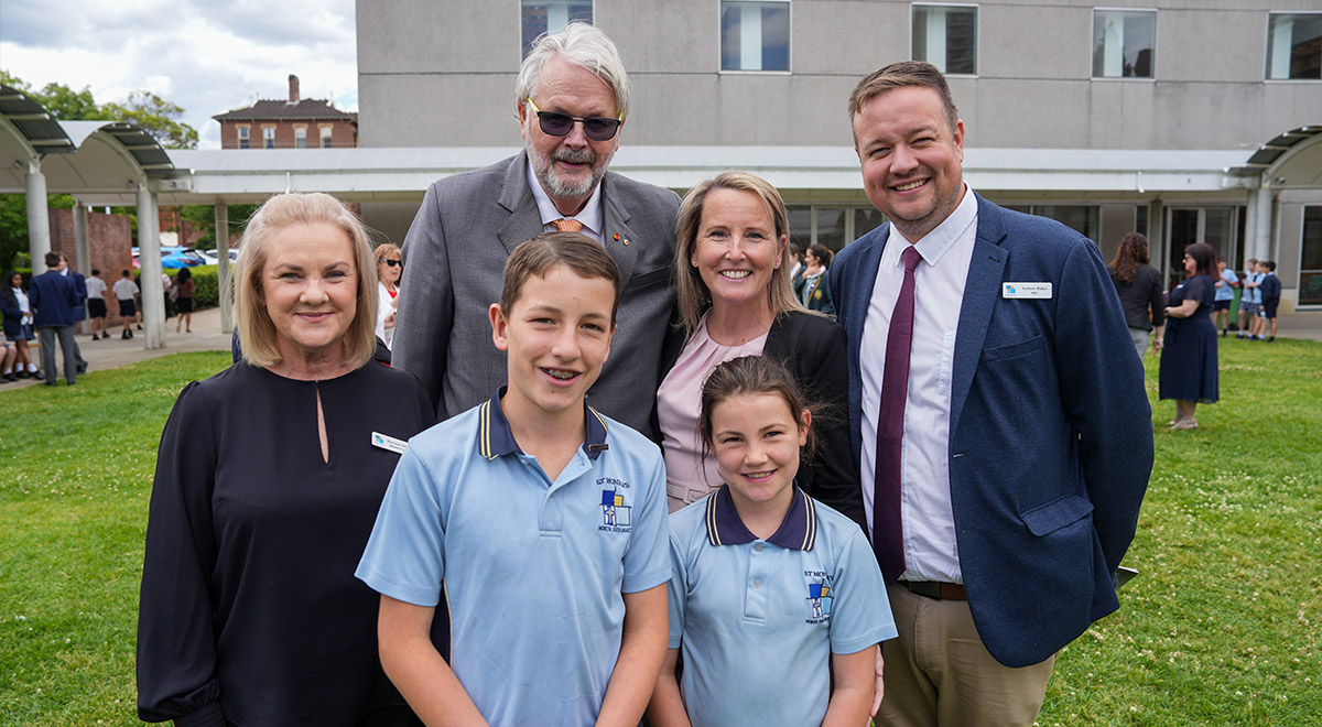 Greg Whitby pictured with students and staff from St Monica's Primary Parramatta, where he started school many years ago.