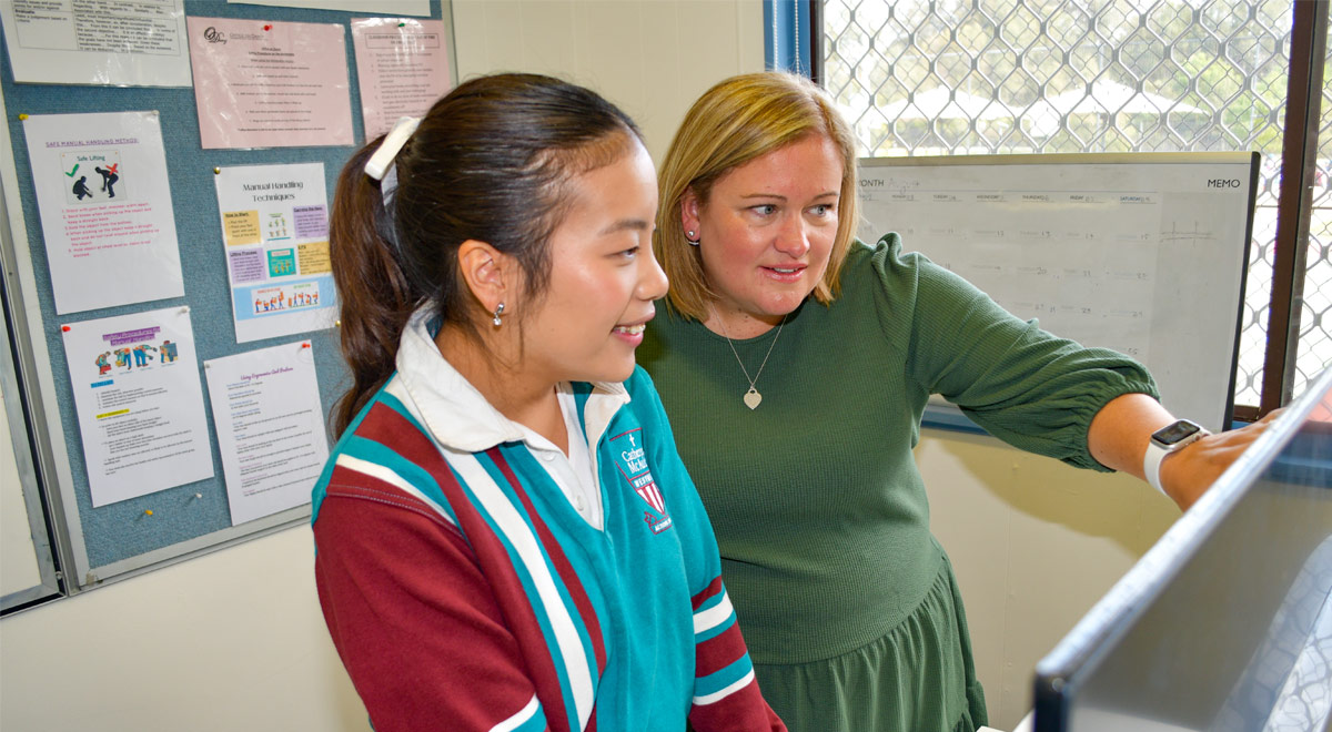 Taryn Grima with a student during a Business Services VET class at Catherine McAuley Westmead.