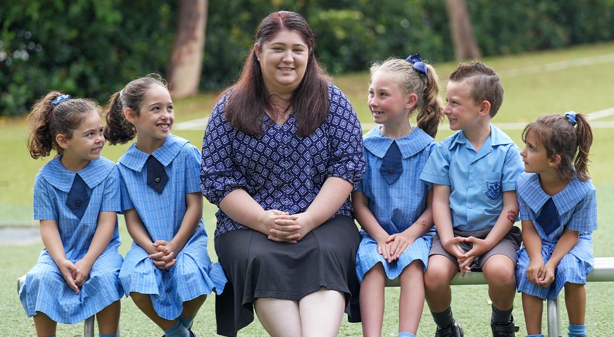New teacher Jaimee Pearson with students at her old school St Monica's Primary in Richmond
